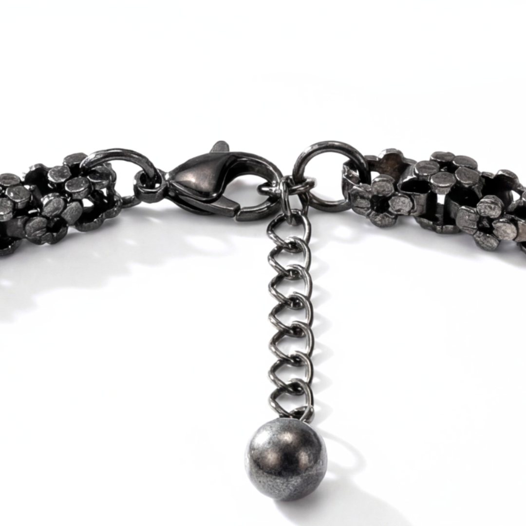 Close-up of a black chain bracelet with a clasp on a white background