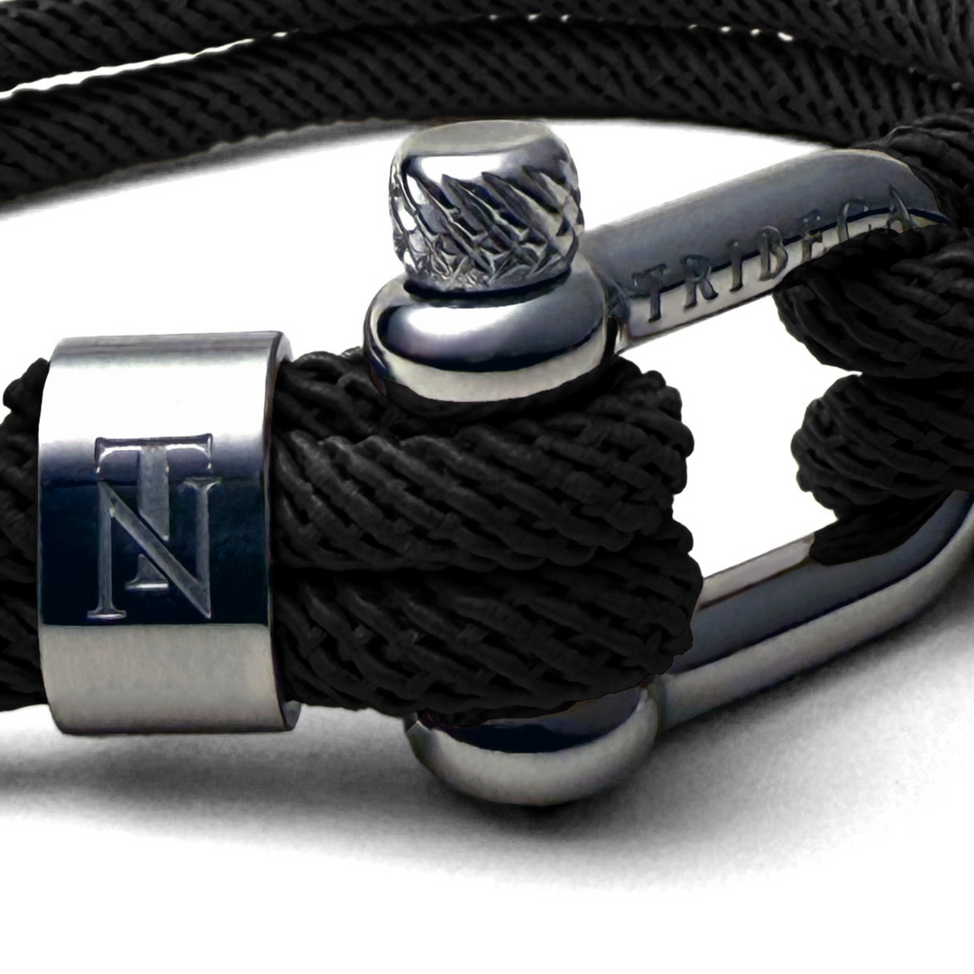 I close image of a stainless steel clasp on a black rope bracelet 