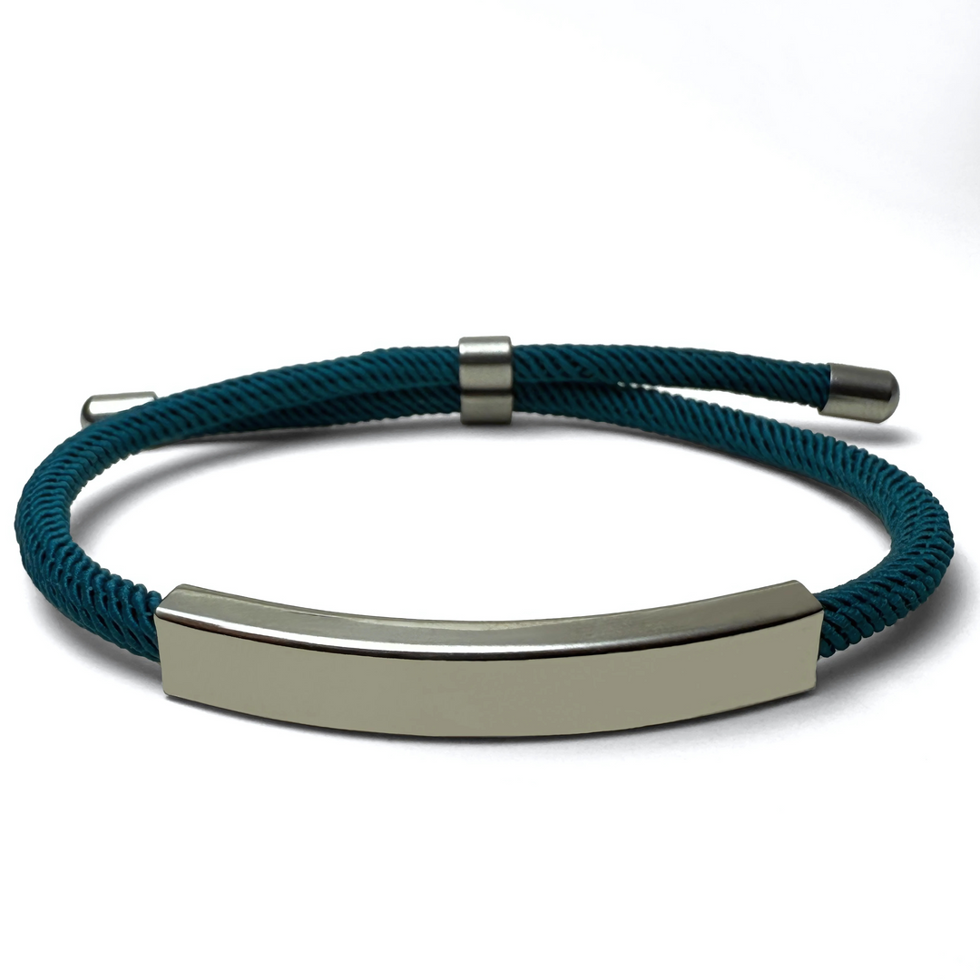 A teal-colored bracelet with a metallic bar centerpiece, displayed against a white background