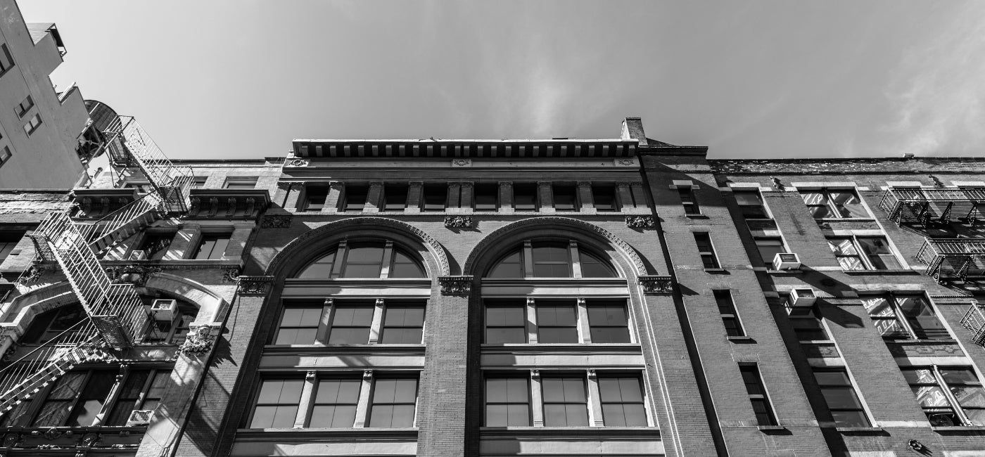 A black and white image of the facade of a building in New York City 