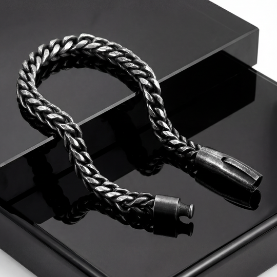 Black braided cable with metal connectors on a reflective black surface
