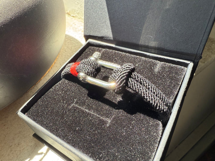 A black and red rope bracelet in a jewelry box