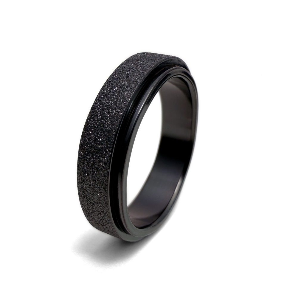 A metallic black ring with a textured surface design