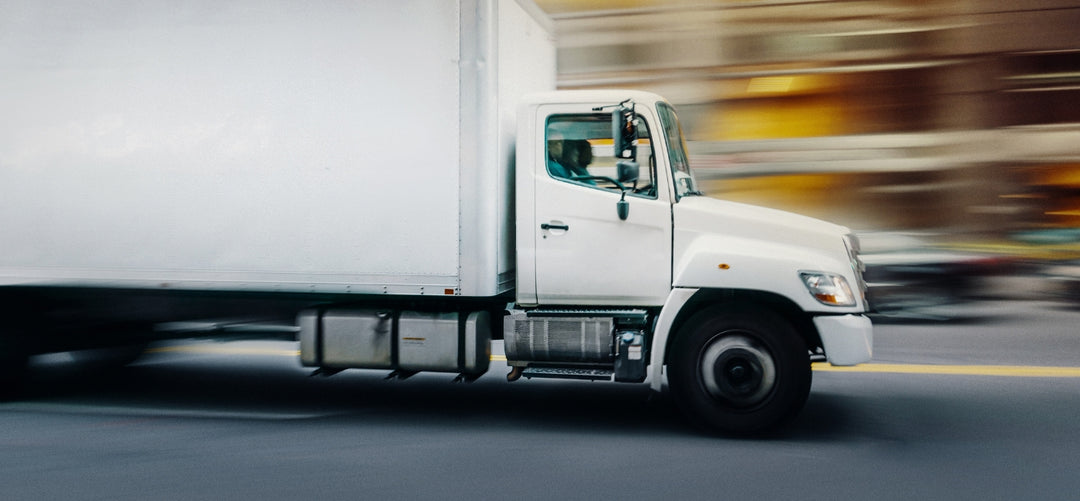 White truck driving on a road with blurred background