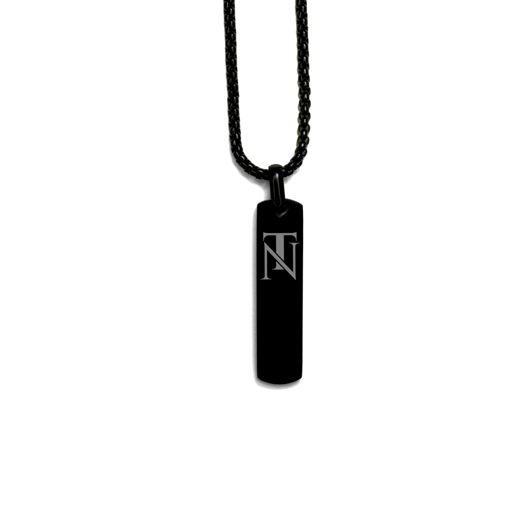 A black pendant necklace with a bar-shaped pendant engraved with the letter 'TN', displayed on a white background.