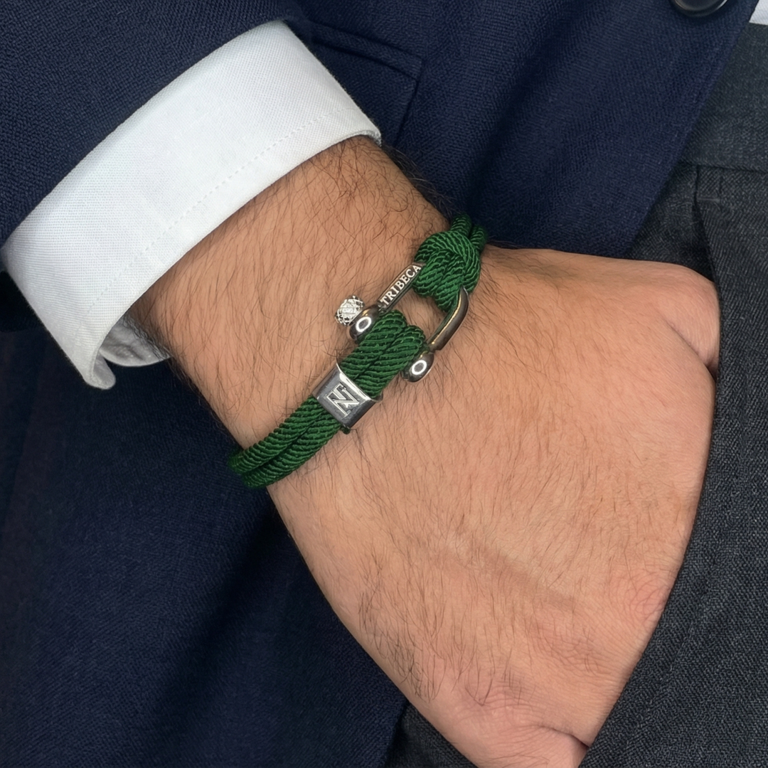 A man wearing dress cloths and a green rope bracelet with metal clasps