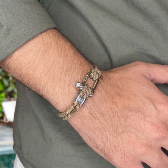 A man wearing a beige rope bracelet with a metal clasp