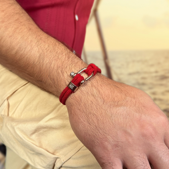 Red bracelet on a wrist with a blurred natural background